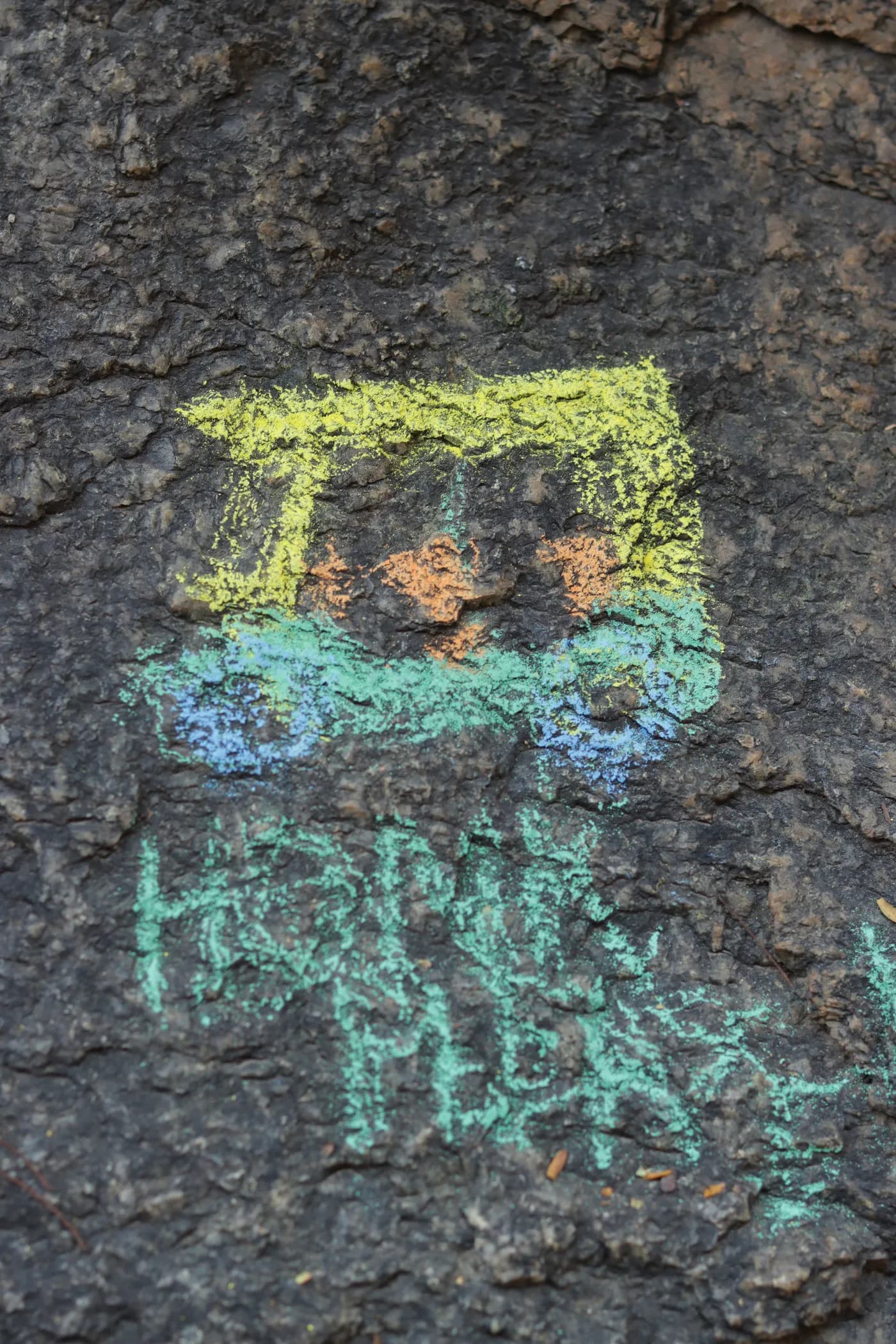 A chalk drawing of an auto-rickshaw on dark stone, with “HONK” written beneath it.