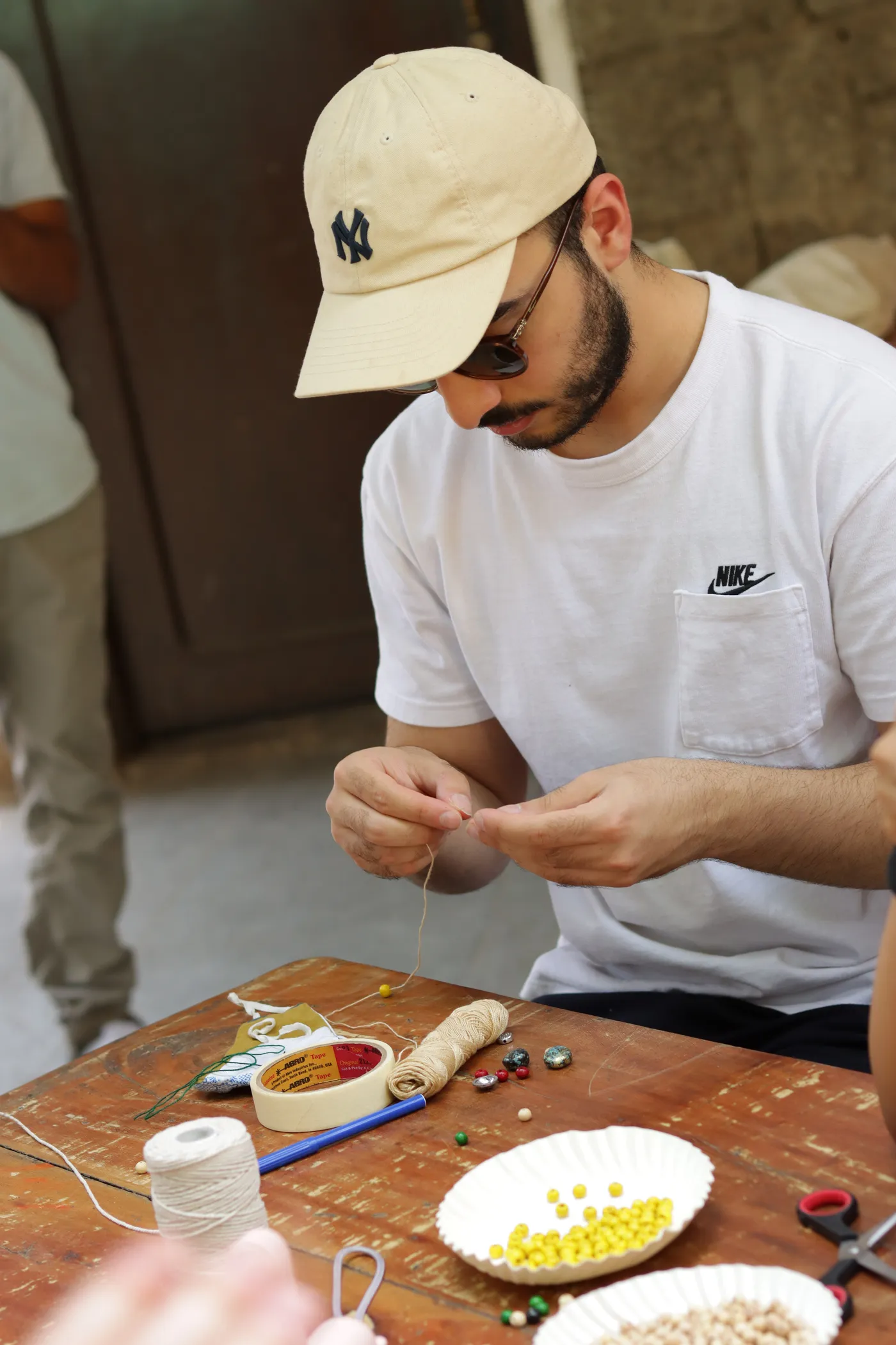 A close view of a visitor knotting a bracelet thread.