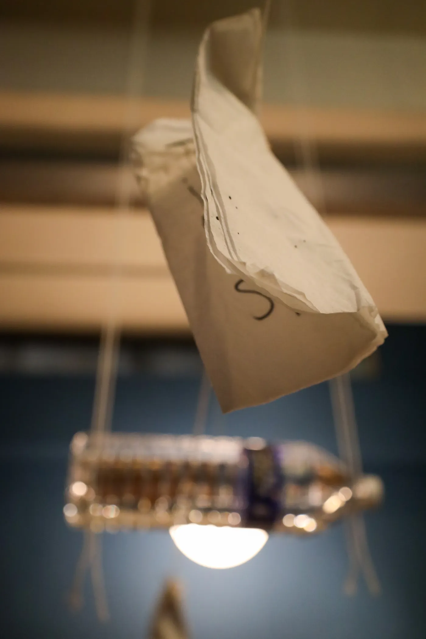 A visitor reaching up to clip their napkin onto the moving string.