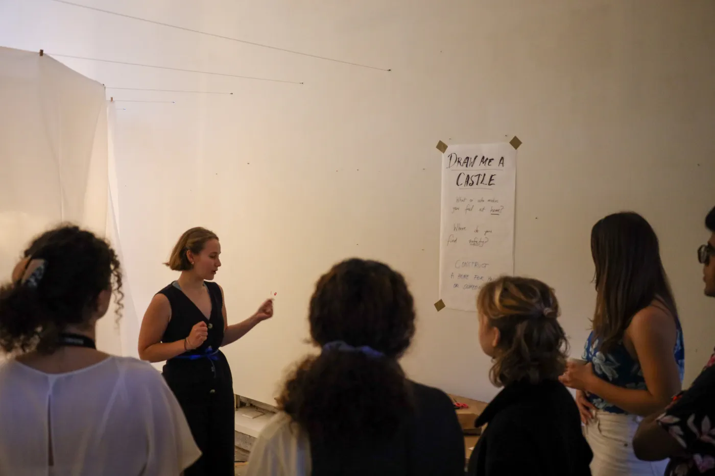 A visitor drawing onto one of the hanging transparent sheets with a marker.