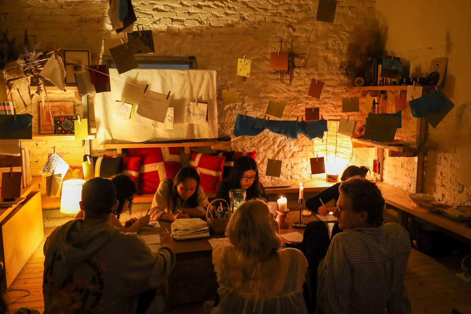 Napkins pegged along strings strung in a wave across the room, lit by candles and fairy lights.